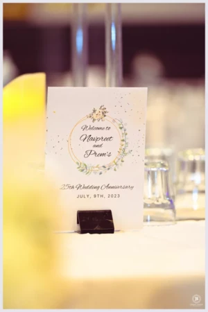 Printed 25th wedding anniversary welcome card placed on a banquet table.