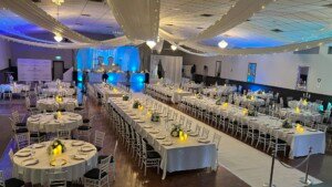 Elevated view of decorated hall with long rectangular and round dining tables.